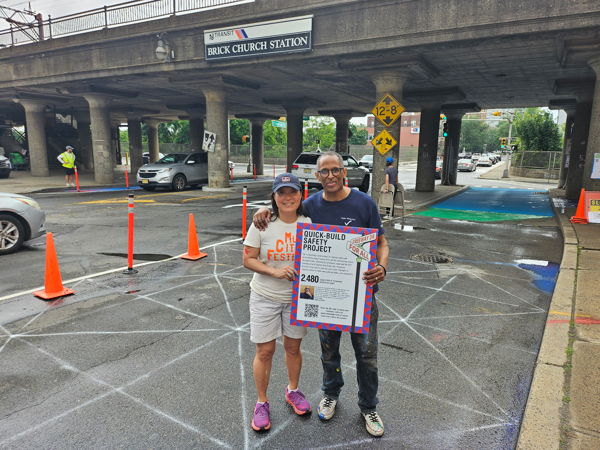 Volunteers and crew marking a crosswalk near the rail overpass