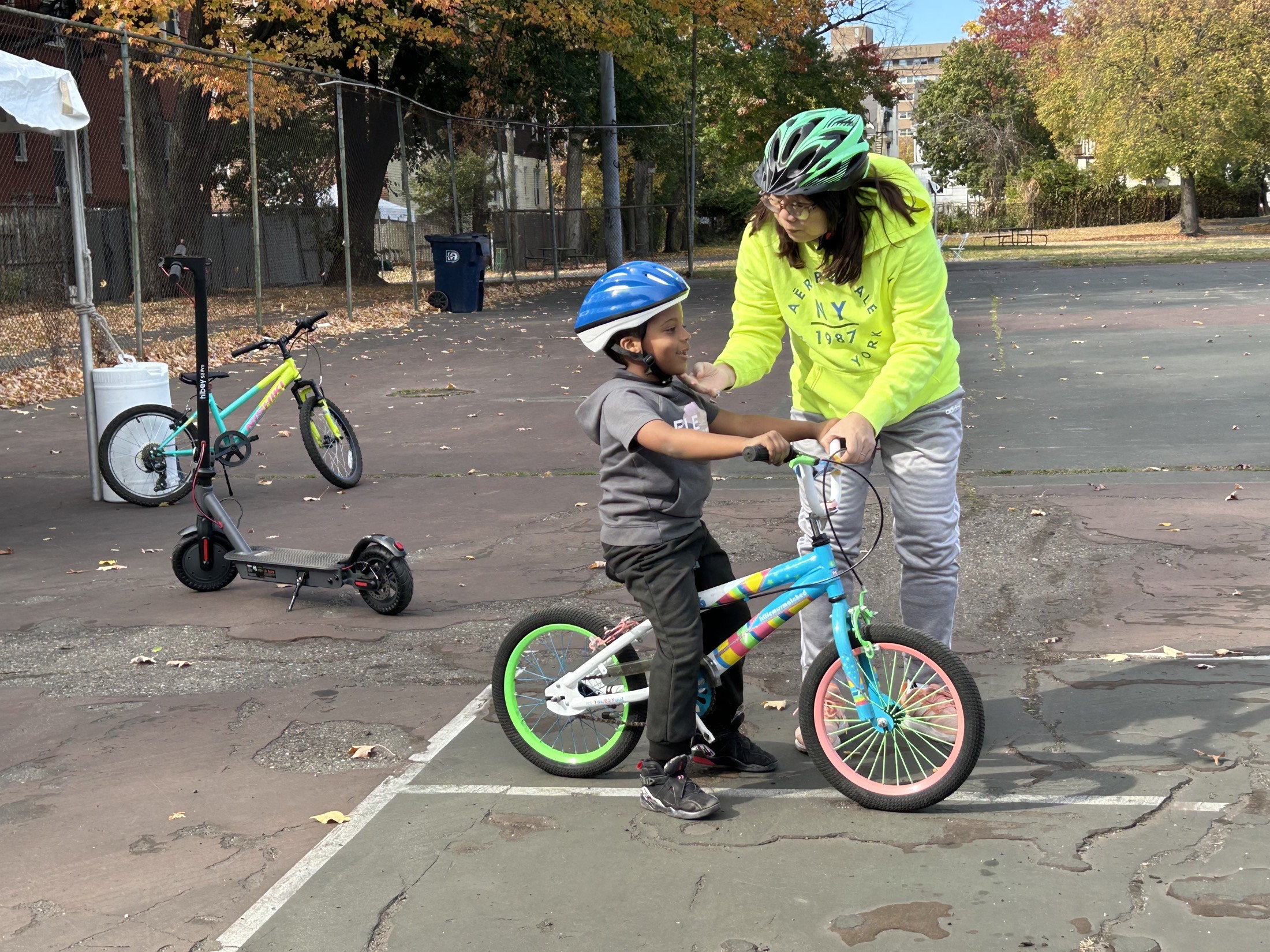A child learning to ride a bike at a community bike event