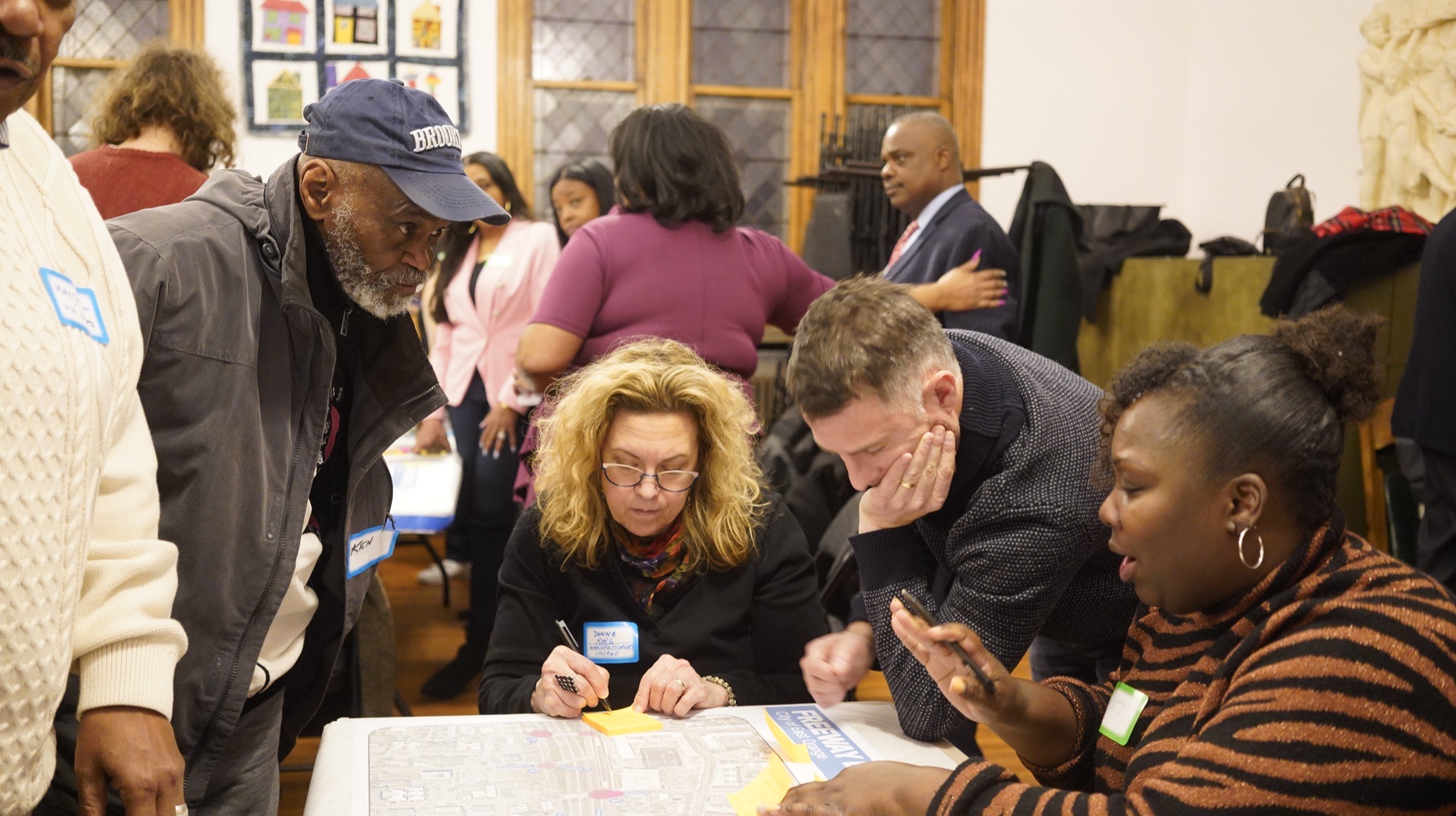 Residents and officials reviewing a corridor map at a community meeting