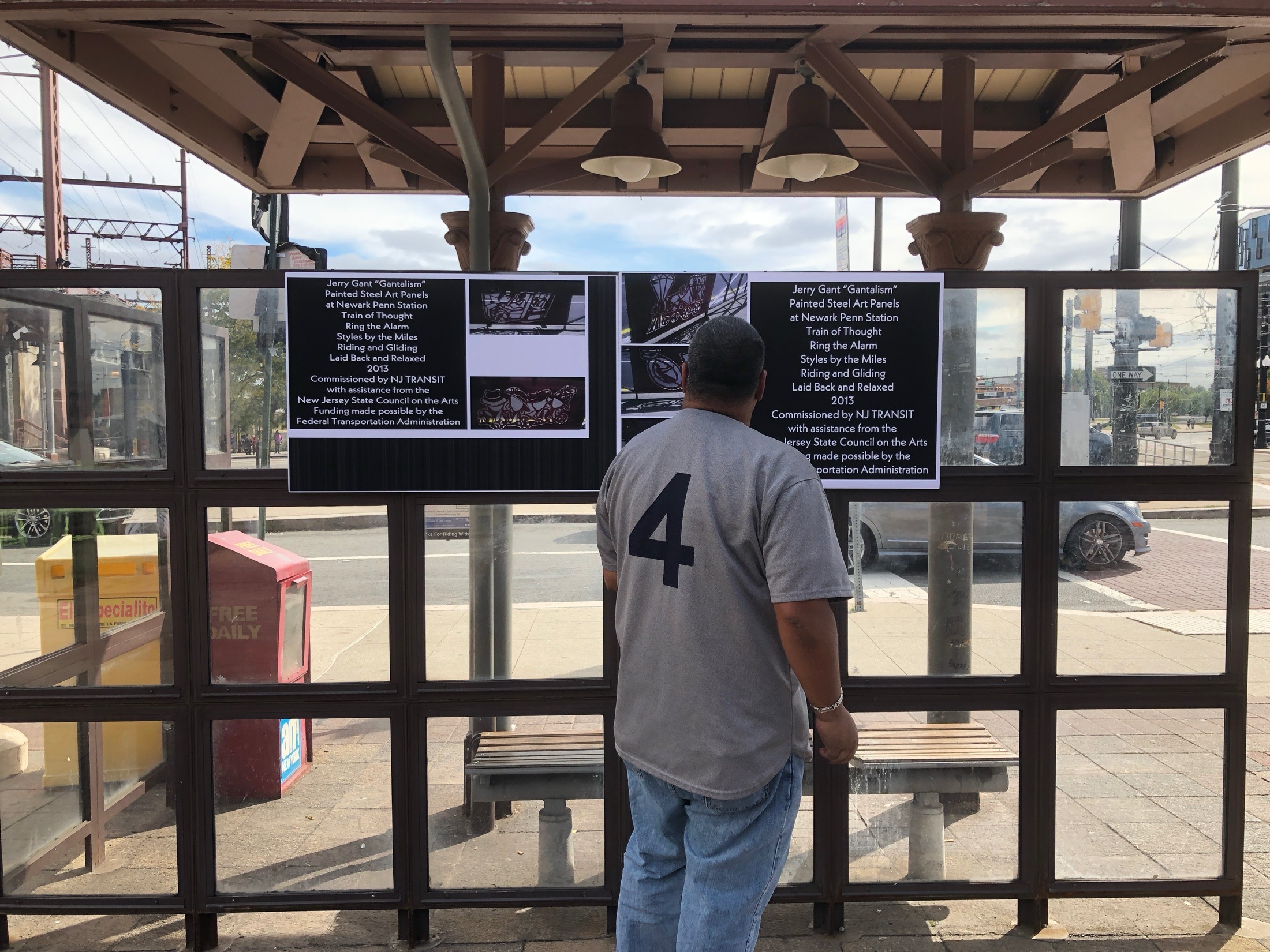 Visitor reading Jerry Gant artwork panels on the station platform