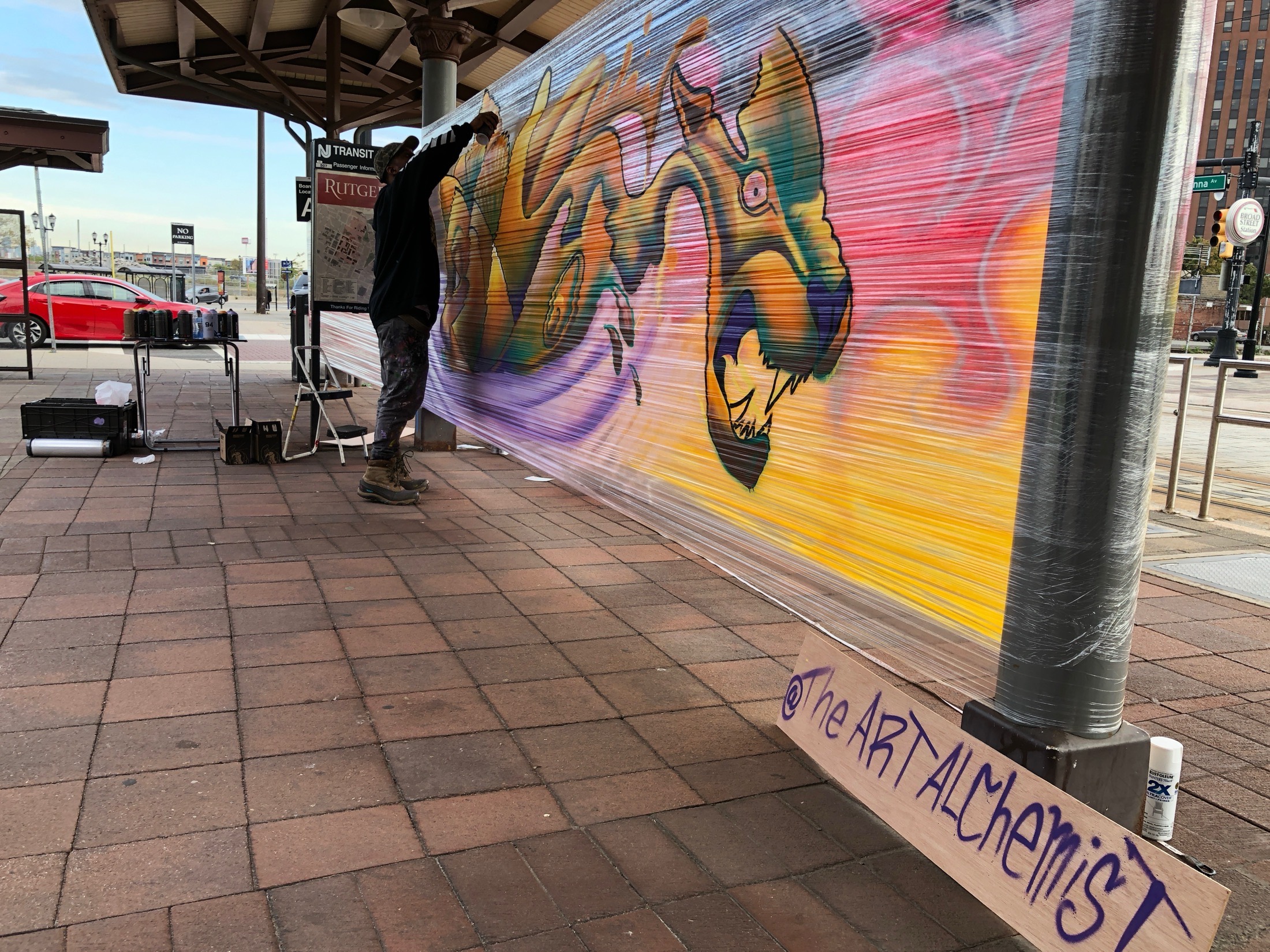 Elijah Minton painting a mural at Broad Street Station