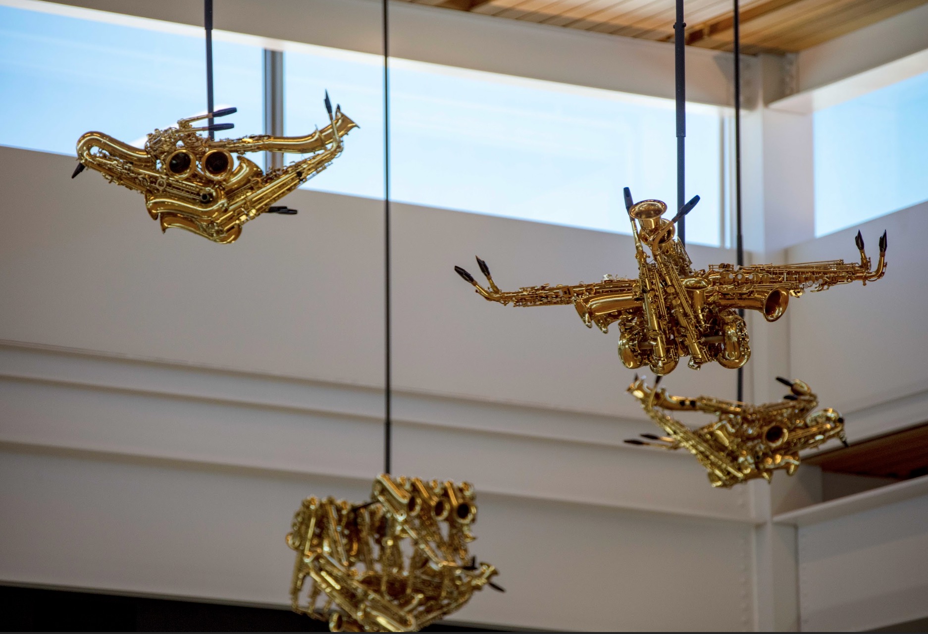 Multiple saxophone-bird sculptures in flight formation