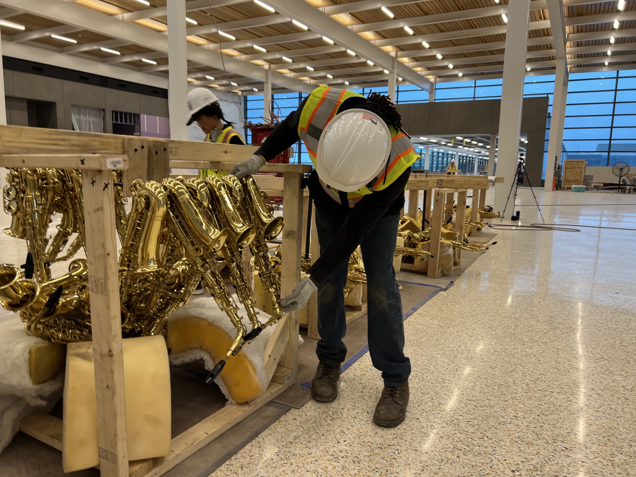 Crew member crating saxophone sculptures on site